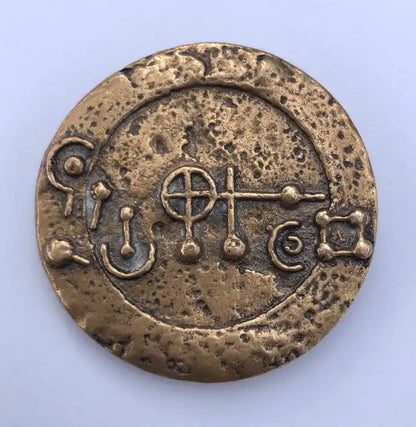 A-Medaillon: rundes bronzefarbenes Medaillon mit eingeprägten Symbolen.