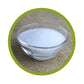 Cristaux blancs de xylitol dans un bol en verre sur un tissu naturel.