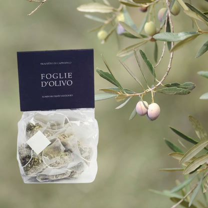 Foglie d'Olivo: Olivenblättertee-Packung neben Olivenzweigen.